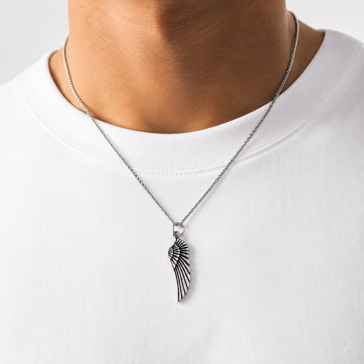 925 Italian Silver Wing Necklace worn on a white T-shirt